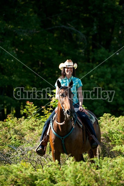 Woman trail riding on Standardbred mare