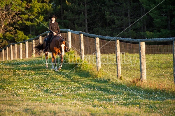 Young woman riding her American Paint horse mare