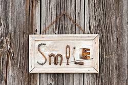 Hand crafted Smile art sign made out of wood and recycled or repurposed farm tools and machinery parts