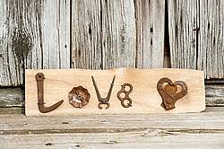 Hand crafted Love art sign made out of wood and recycled or repurposed farm tools and machinery parts