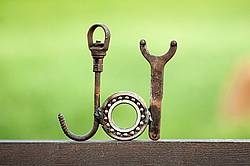 Hand crafted joy garden art sign made out of recycled or repurposed farm tools and machinery parts then welded together