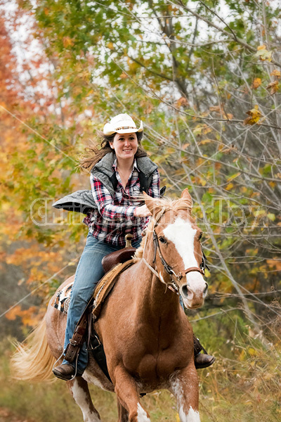 Young woman riding Paint horse 
