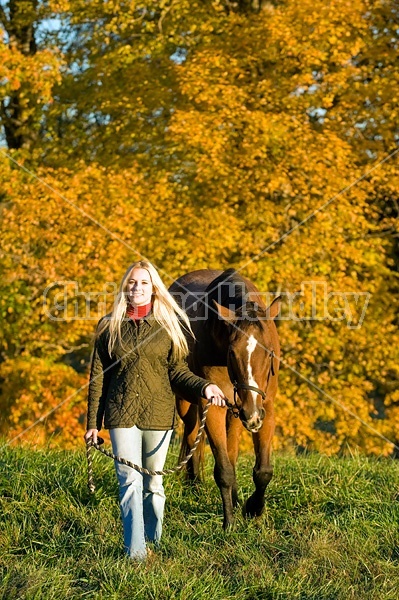 Woman with horse in pasture