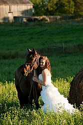 Woman in wedding dress with horse.