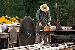 Man operating a circular saw mill on the farm