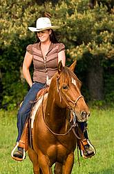 Young woman riding chestnut horse