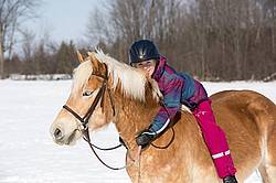 Young girl riding her pony bareback in the winter. 