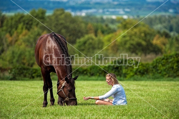 Young woman with her dark bay horse