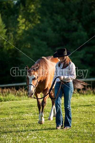 Young woman catching her Paint mare out of the paddock