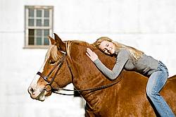Young woman riding Belgian horse bareback.