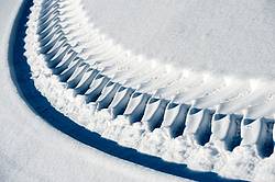 Photo of tractor tire tracks in the snow
