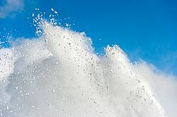 Photo of snow from snowblower against blue sky