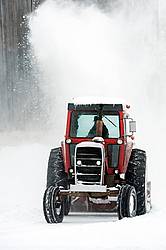 Snow blowing around the farm with a tractor and snow blower